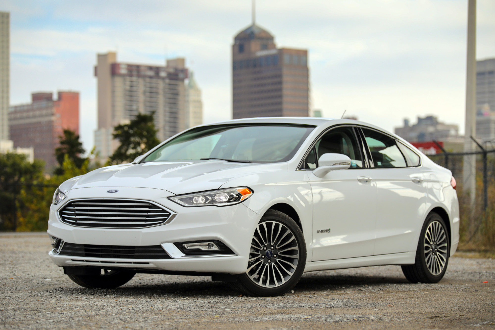 Ford Fusion Hybrid in driveway with city in background